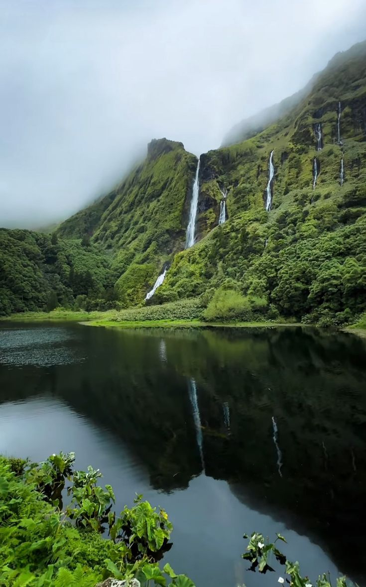 Waterfalls falling into a still lagoon on Flores, Azores